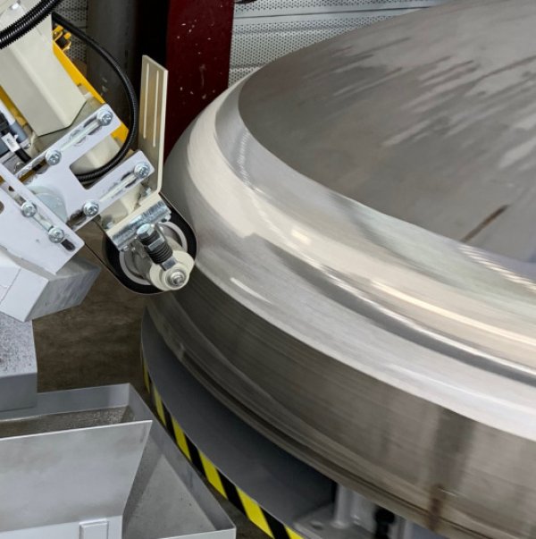 Gros plan sur une machine FARROS de meulage de fonds de la gamme H FARROS, machine-outil de meulage industriel avec tête flottante de meulage et tête de meulage industrielle travaillant l’extérieur d’un fond de cuve inox grande dimension, pour le meulage de fonds bombés, elliptiques ou hémisphériques, le traitement des fonds de cuves, la reprise de soudures, le meulage de pièces courbes et de formes complexes, avec finition homogène des surfaces en chaudronnerie et tôlerie.