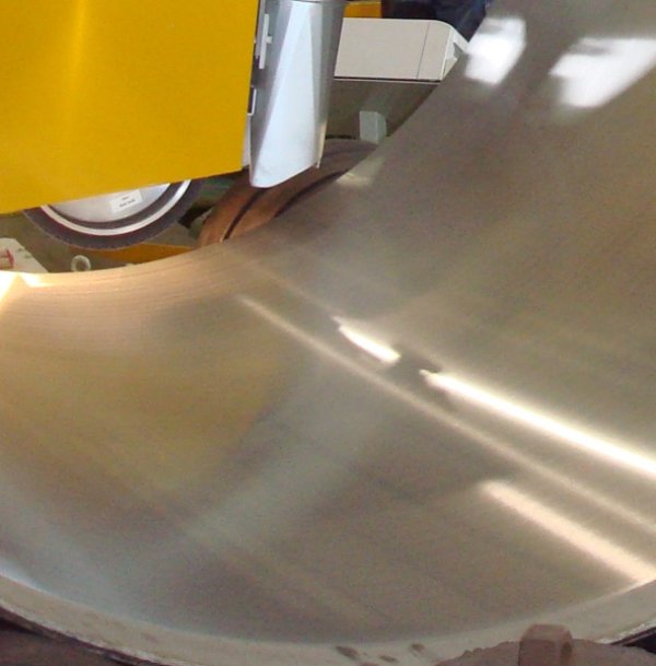 Installation de meulage Farros Grinding Systems en action, mettant en évidence une machine de meulage des fonds travaillant sur un réservoir métallique. L'image montre un meulage de précision avec des équipements de meulage industriel, y compris une installation de préparation des bords pour le meulage de tuyaux, démontrant la capacité des machines de meulage à effectuer des installations de meulages spéciales. La machine, partie d'installations de meulage polyvalentes, illustre le meulage extérieur des appareils industriels, confirmant Farros Grinding Systems comme leader en meulage industriel.